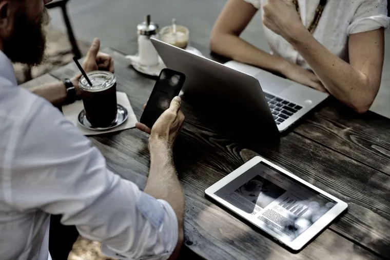 guys on table with ipad and laptop drinking