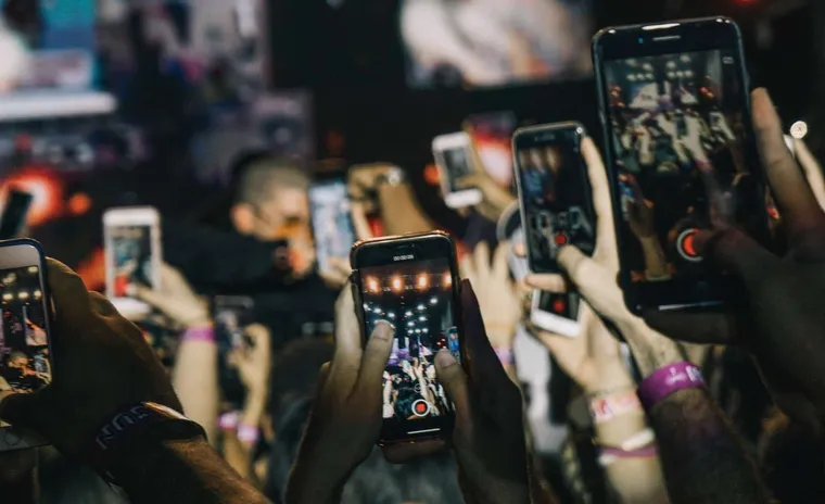 people holding their phone in the air