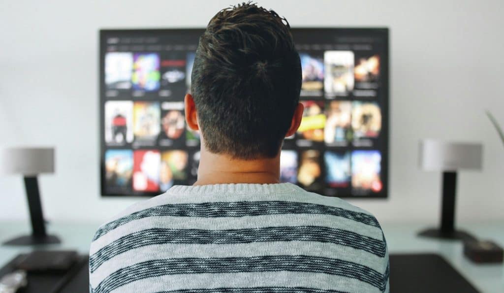 Guy in front of TV watching netflix