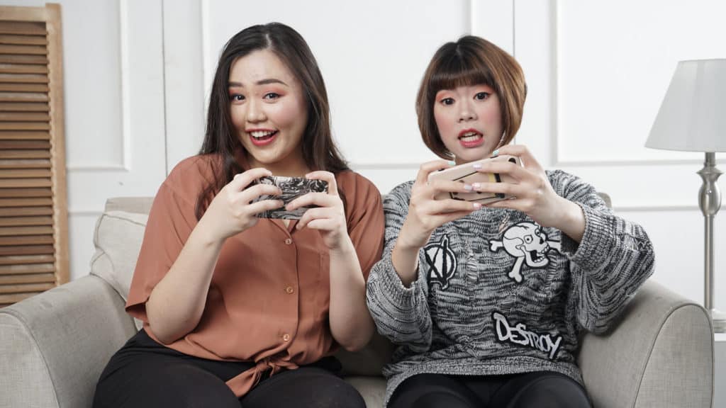 Two Girls Playing iPhone on Couch